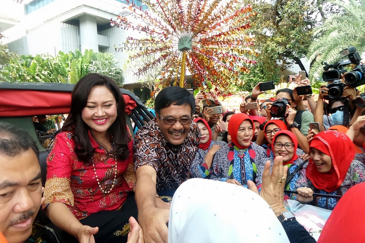 Mantan Gubernur DKI Jakarta Djarot Saiful Hidayat didampingi istri Happy Farida menyalami warga sebelum diarak menggunakan kereta kencana ketika pelepasan di depan Balai Kota DKI Jakarta, Minggu (15/10/2017). Djarot bersama istri diarak menggunakan kereta kencana diiringi oleh pegawai dan BUMD dari Balai Kota ke Gedung Joang 45 sebagai bentuk ucapan terima kasih atas pengabdiannya sebagai Gubernur DKI Jakarta.