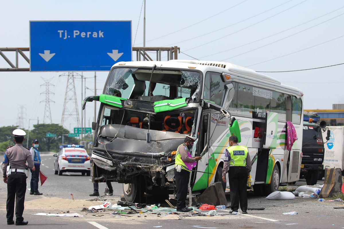 Polisi melakukan pemeriksaan di lokasi kecelakan bus pariwisata dengan truk di Tol Dupak - Tanjung Perak Surabaya, Jawa Timur, Sabtu (5/3/2022). Kecelakaan antara bus pariwisata bernopol D 7610 AT yang memuat rombongan peziarah dengan truk 'Colt Diesel' nomor polisi W 9948 Z itu diduga disebabkan salah satu penumpang bus merebut kendali kemudi dari sopir bus dan menabrak truk 'Colt Diesel' dari arah berlawanan. Dalam kecelakaan itu sopir truk dan kernetnya meninggal dunia di lokasi kecelakaan.