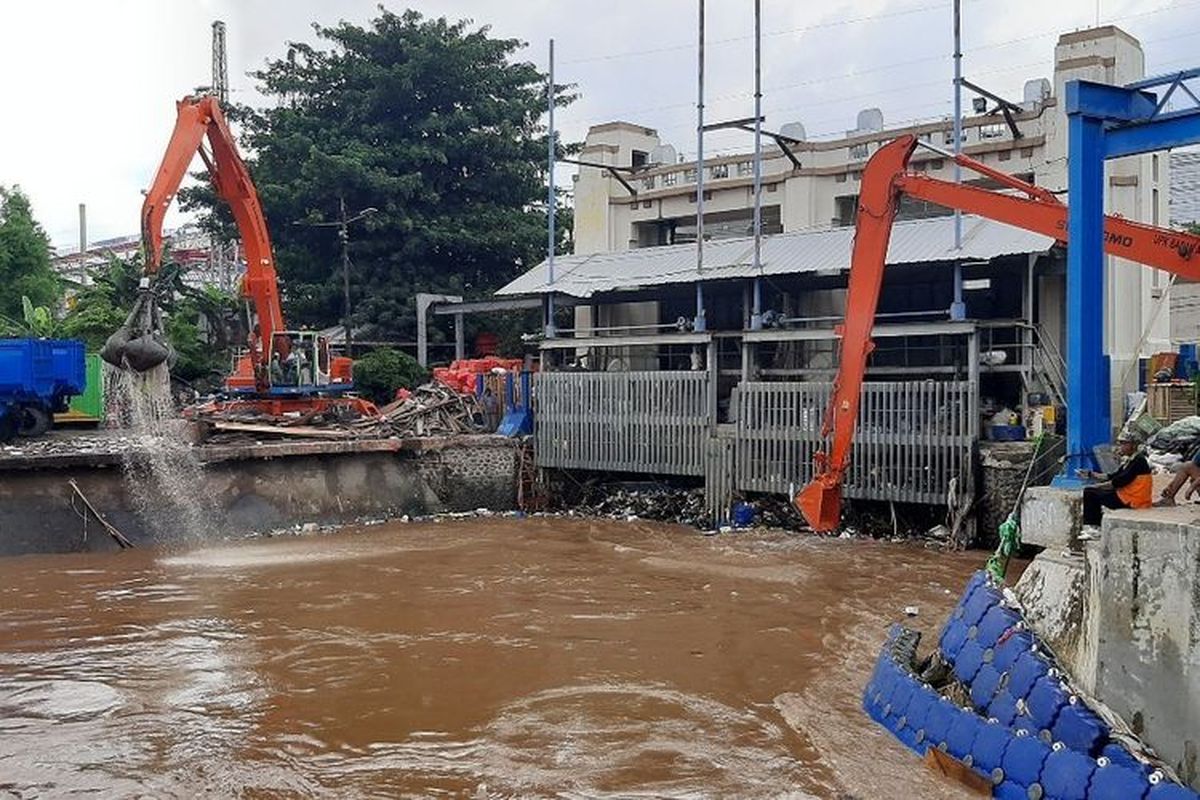 Dua unit alat pengeruk beroperasi mengangkut sampah yang tertahan di Pintu Air Manggarai, Kamis (2/1/2019).(KOMPAS.com/Ardito Ramadhan D)