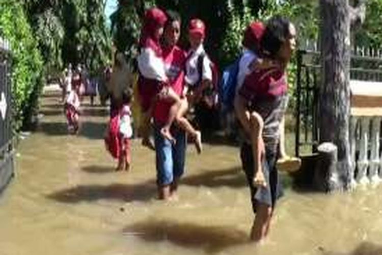Lantaran sekolah tergenag banjir sejumah orang tua sd dan TKI di Pinrang terpaksa mengendong anaknya ke sekolah agar tidak basah kuyup atau tenggelam di kanal dan saluran jalan. 