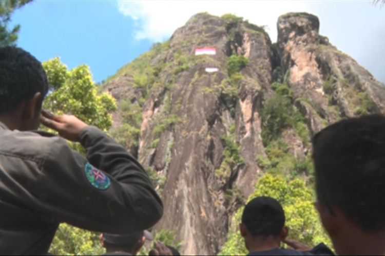 Peserta upacara melakukan hormat bendera,pada saat pengibaran bendera Merah Putih berlangsung di tebing gunung Sepikul kecamatan Watulimo kabupaten Trenggalek,Jawa Timur (17/08/2017)