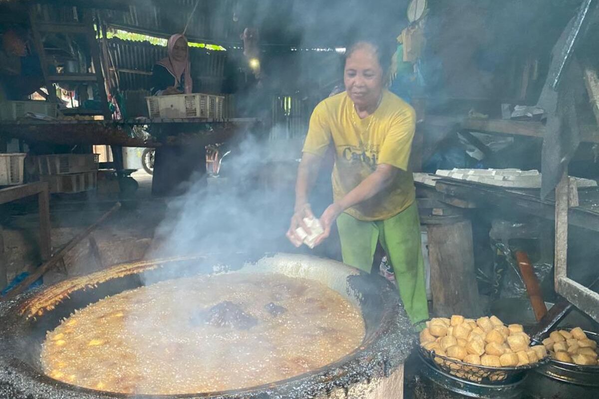 Sri, pengusaha Tahu di kawasan Tanjung Piayu, Batam, Kepri tengah asik menggoreng tahu di Rumah Produksi miliknya. saat ini kenaikan harga kedelai membuat dirinya dan sejumlah pengusaha serta pedagang Tahu dan Tempe resah.