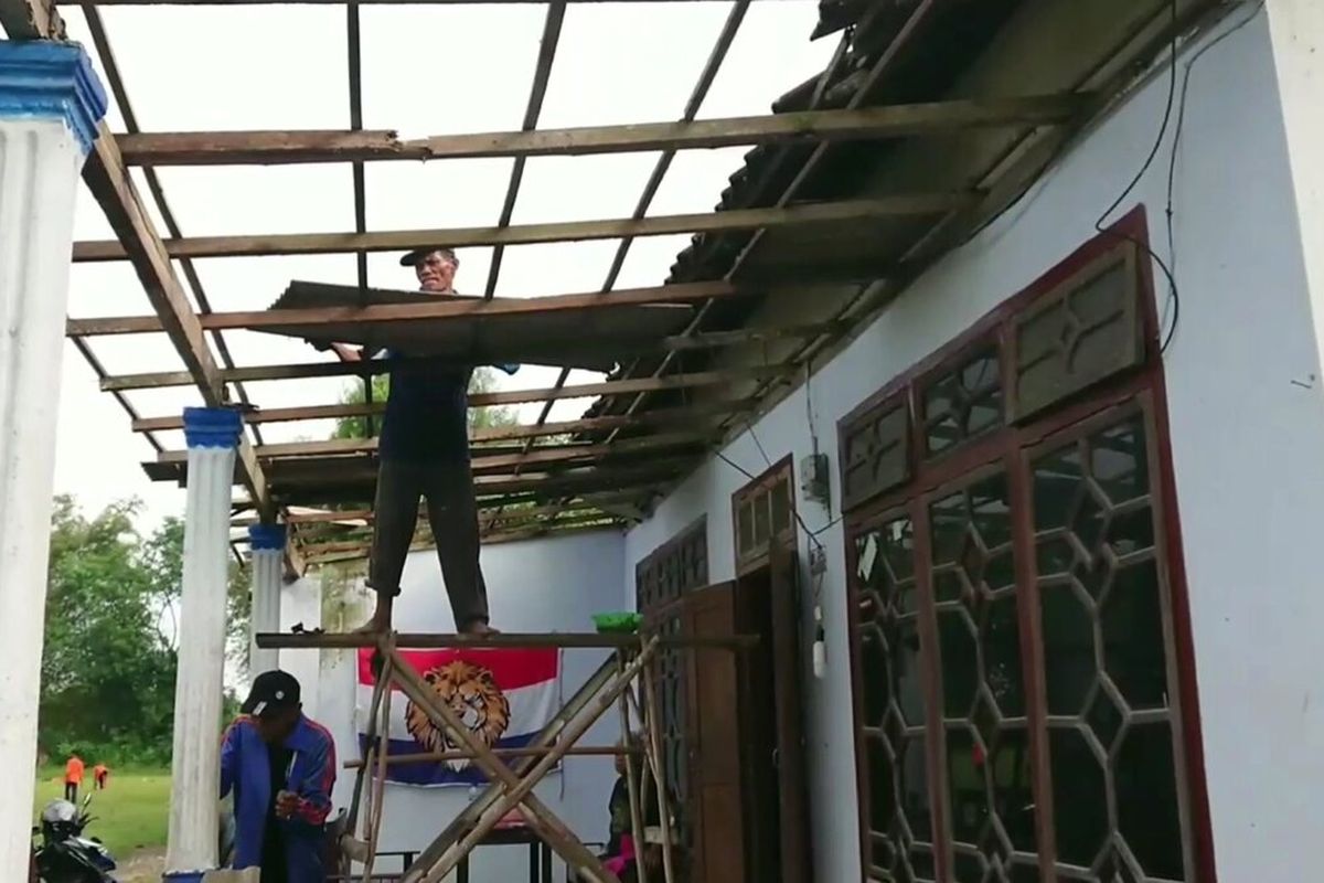 Warga gotong royong perbaiki atap rumah yang rusak,akibat tiupan angin dari baling-baling helikopter yang mendarat darurat di lapangan Rejotangan Tulungagung Jawa Timur, Kamis (23/02/2023)