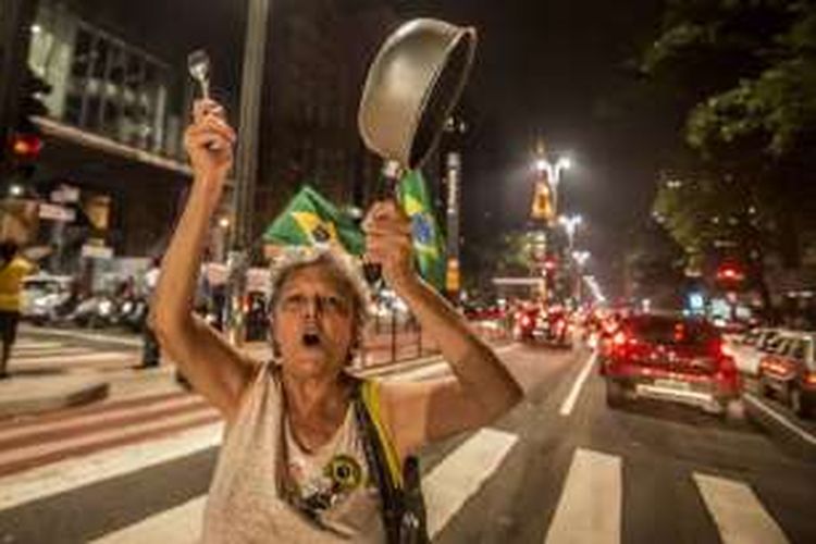 Ribuan demonstran turun ke jalan di Sao Paulo, Brasil, Minggu (17/4/2016). Mereka terdiri dari massa  pro dan anti  Presiden  Dilma Rousseff, yang sedang menghadapi upaya pemakzulan dari parlemen. Tampak di gambar ini seorang demonstran di Sao Paulo.