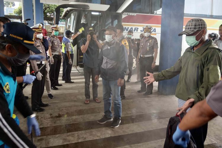 Penumpang bus yang turun di Terminal Bawen Kabupaten Semarang menjalani penyemprotan disinfektan.