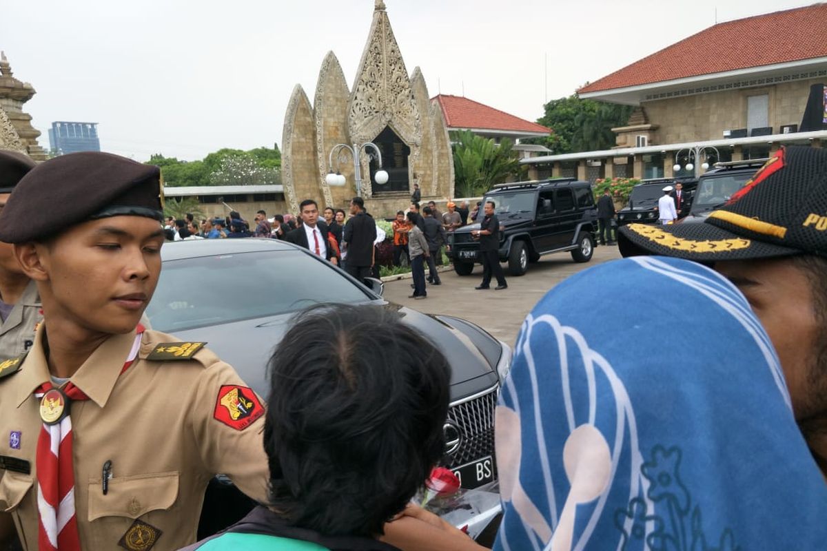 Sejumlah masyarakat yang turut antre di luar kawasan Taman Makam Pahlawan (TMP) Kalibata, Jakarta Selatan, membawa bunga untuk diserahkan kepada keluarga Susilo Bambang Yudhoyono (SBY), Minggu (2/6/2019).