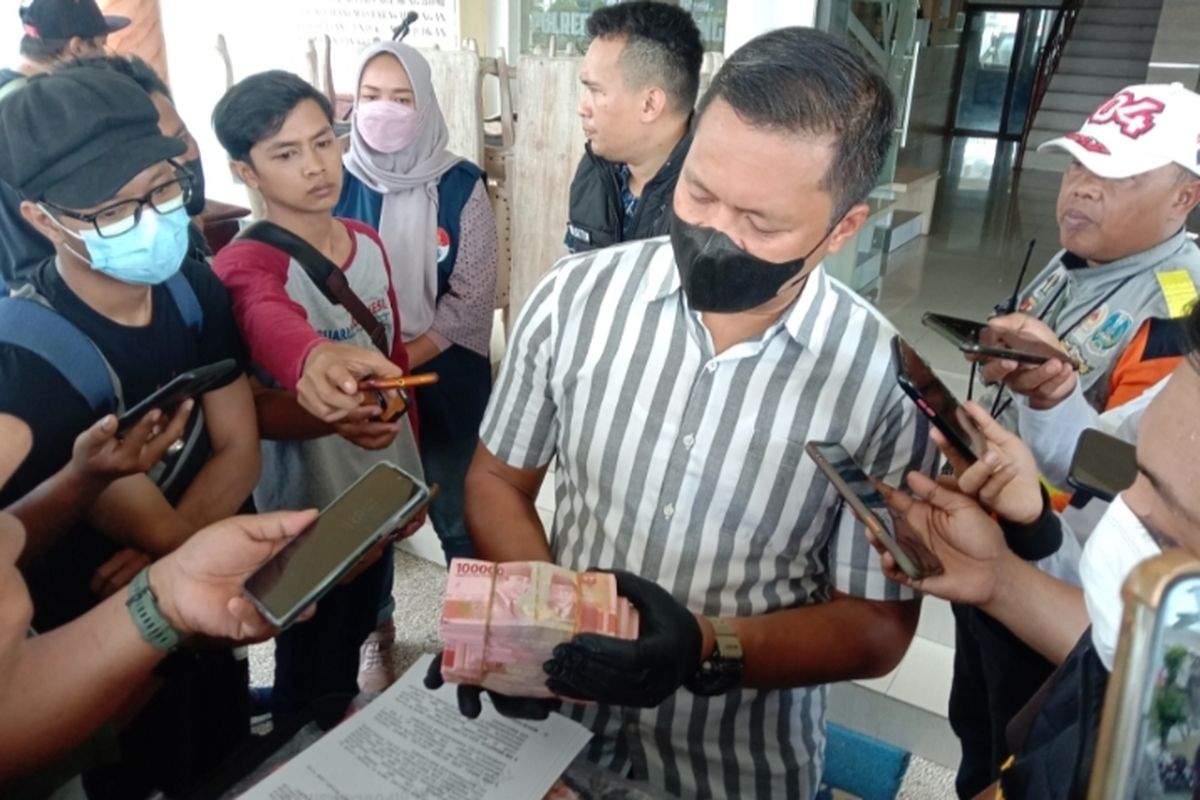 Polisi saat menunjukkan barang bukti uang palsu 