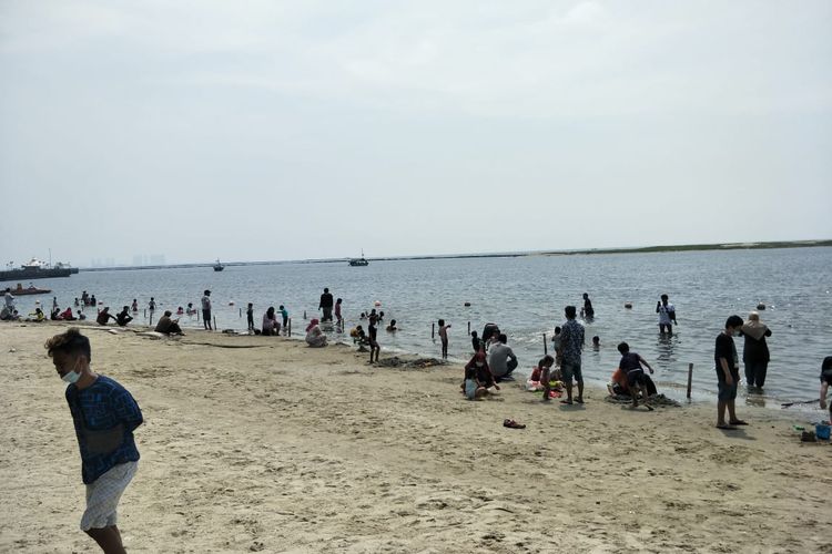 Kawasan wisata Taman Impian Jaya Ancol, tepatnya di Pantai Timur, ramai dikunjungi wisatawan pada hari pertama Idul Fitri, Kamis (13/5/2021).