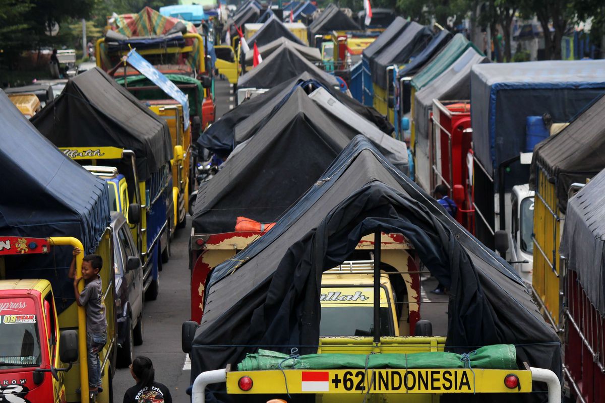 Deretan truk berbagai jenis terparkir saat sopir yang tergabung dalam Gerakan Sopir Jawa Timur (GSJT) berunjuk rasa di depan Kantor Dinas Perhubungan, Surabaya, Jawa Timur, Jumat (11/3/2022). Dalam aksinya mereka menuntut ketegasan pemerintah dalam penerapan kebijakan regulasi angkutan logistik terkait kelebihan muatan (over loading) dan dimensi (over dimension) angkutan truk barang.