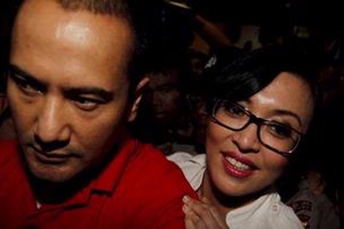 Angelina Sondakh (kanan) berlindung di balik adik Adjie Massaid, Muji Massaid , seusai memberikan keterangan sebagai saksi dalam sidang Muhammad Nazaruddin, terdakwa kasus dugaan suap wisma atlet SEA Games 2011, di pengadilan Tindak Pidana Korupsi, Jalan HR Rasuna Said,Jakarta Selatan, Rabu (15/2/2012). Selain Angelina, I Wayan Koster juga turut dihadirkan sebagai saksi dalam persidangan ini. Keduanya dianggap mengetahui aliran dana wisma atlet SEA Games dan diduga menerima uang wisma atlet sebesar Rp 2 miliar dan Rp 3 miliar. 