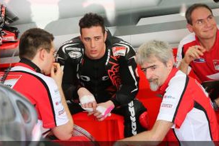 Pebalap Ducati asal Italia Andrea Dovizioso (tengah, hitam) bediskusi dengan kru timnya pada hari ketiga sesi uji coba MotoGP 2014 di Sirkuit Sepang, Malaysia, Kamis (6/2/2014).