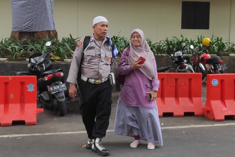 Bripka Madih ditemani sang istri saat menyambangi Polda Metro Jaya untuk klarifikasi kasus penyerobotan tanah yang menimpa dirinya, Minggu (5/2/2023). 