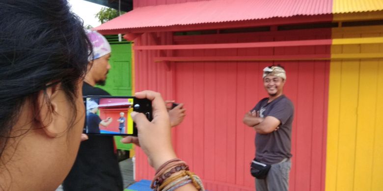 Wisatawan berfoto di depan rumah yang dikenal dengan Kampung Pelangi di Kota Pangkalan Bun, Kotawaringin Barat, Kalimantan Tengah, Sabtu (17/2/2018). Kampung Pelangi merupakan salah satu obyek wisata buatan yang kini dikembangkan oleh Pemerintah Kabupaten Kotawaringin Barat untuk menarik kunjungan wisatawan nusantara maupun mancanegara.