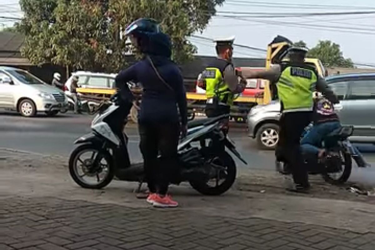 Seorang petugas polisi menendang pengendara di Cikupa, Kabupaten Tangerang, Jumat (30/8/2019)