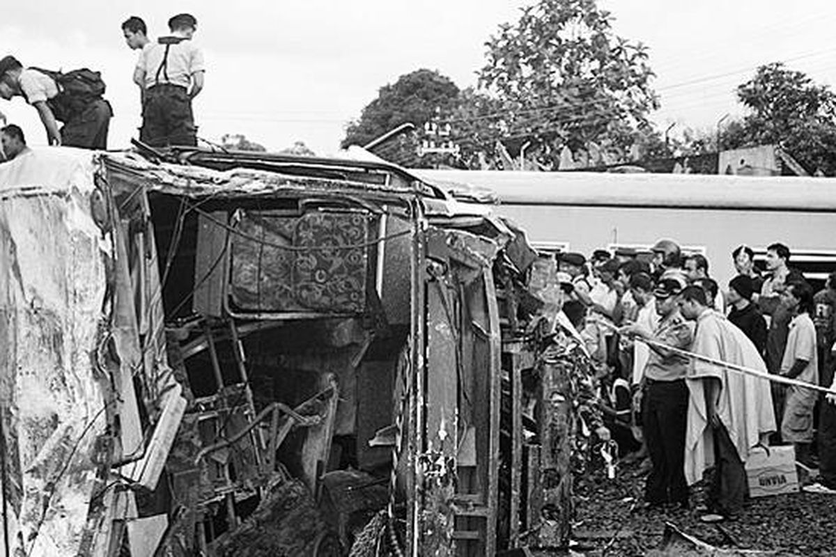 Polisi mengevakuasi korban tabrakan antara bus Harapan Jaya jurusan Surabaya-Tulungagung dan KA Rapih Dhoho dari Kediri menuju ke Malang di perlintasan kereta berpalang pintu di Jalan Brigjen Katamso, Kota Kediri, Jawa Timur, Senin (23/2).  
