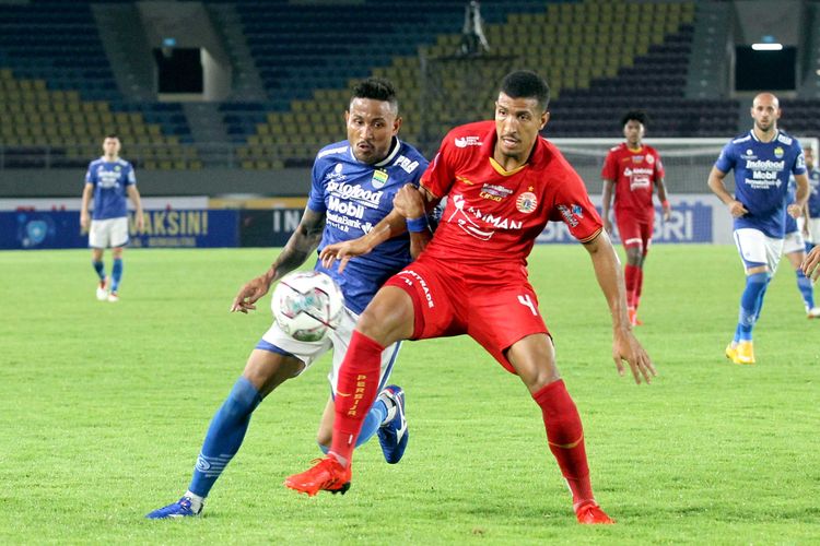 Penyerang Persib Bandung Wander Luiz (biru), mencoba melepaskan diri dari kawalan bek Persija Jakarta Yann Motta (merah), saat kedua tim bertemu dalam lanjutan pertandingan Liga 1 2021-2022 pekan ke-12 di Stadion Manahan, Solo, Sabtu (20/11/2021).