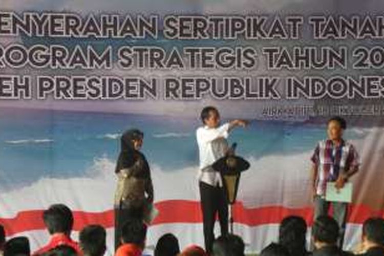 Presiden Jokowi memberikan kuis berhadiah sepeds kepada warga yang hadir di acara penyerahan sertifikat tanah di Minahasa Utara, Selasa (18/10/2016).