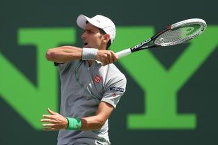 Petenis Serbia Novak Djokovic memukul bola ke arah Rafael Nadal dari Spanyol saat bertanding pada laga final Sony Open Tennis di Crandon Park Tennis Center, Miami, Minggu (30/3/2014).