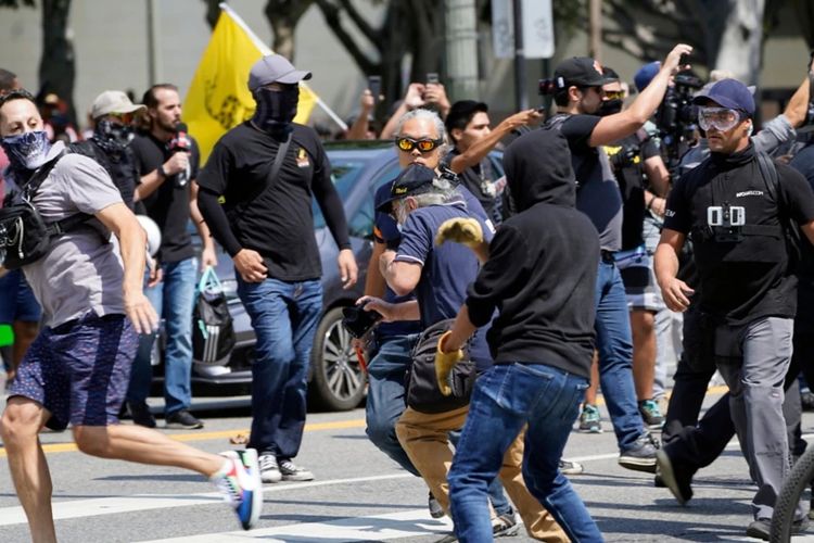 Demonstran anti vaksin (kiri) terlibat pertikaian dengan orang-orang yang berlawanan pendapat dengan mereka dalam sebuah unjuk rasa anti vaksin di depan Balai Kota Los Angeles, AS, pada 14 Agustus 2021.