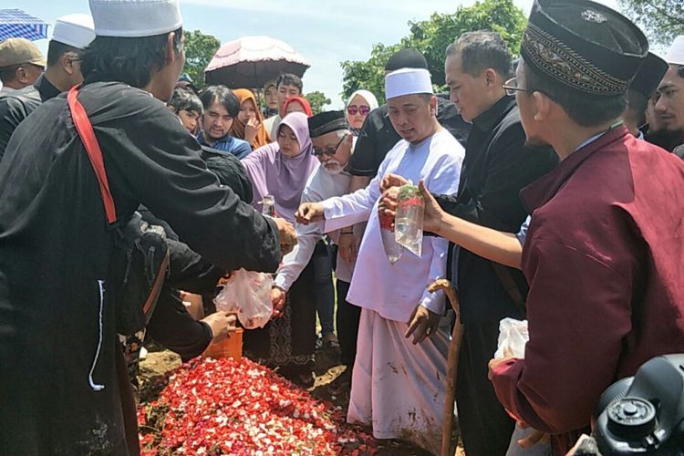 Penyanyi dan pencipta lagu Opick (berbusana dan berpeci putih) berdiri di samping pusara istri keduanya, Wulan Mayasari, di TPU Semper, Cilincing, Jakarta Utara , Senin (19/3/2018).