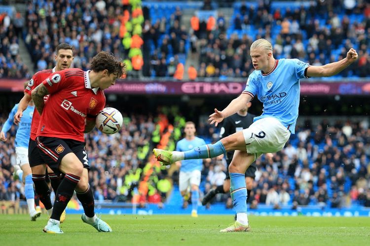 Penyerang Manchester City Erling Haaland melepas tembakan kontra Man United pada lanjutan laga Liga Inggris di Stadion Etihad, Manchester, Minggu (2/10/2022).