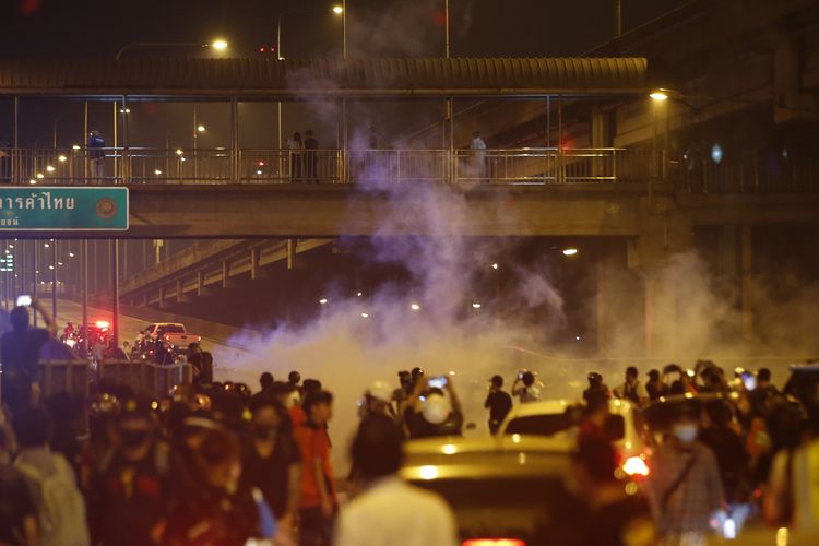 Polisi antihuru-hara menembakkan gas air mata ke arah pedemo pro-demokrasi, dalam aksi unjuk rasa di Bangkok, Thailand, pada Minggu (28/2/2021). Massa menuntut reformasi kerajaan dan polisi lepas dari campur tangan politik.