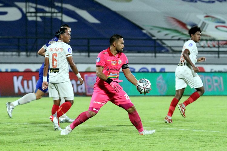 Penjaga gawang Persija Jakarta Andritany Ardhiyasa (pink) bersiap menendang bola saat pertandingan melawan PSIS Semarang pada pekan 18 Liga 1 2021-2022 yang berakhir dengan skor 1-2 di Stadion Kapten I Wayan Dipta Gianyar, Bali, Kamis (6/1/2021) malam.