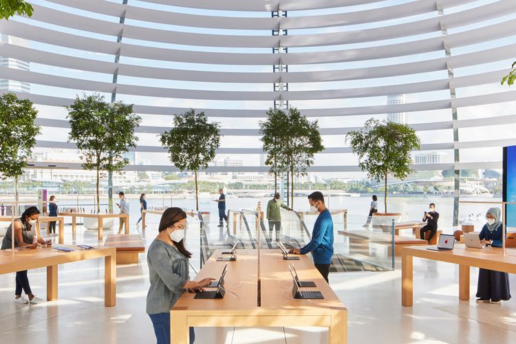 Tampilan interior Apple Marina Bay Sands yang dilapisi dengan 114 kaca dan ditopang dengan 10 tiang di sekelilingnya. Ada pula beberapa tanaman hijau yang menghiasi sekeliling gerai Apple Store.