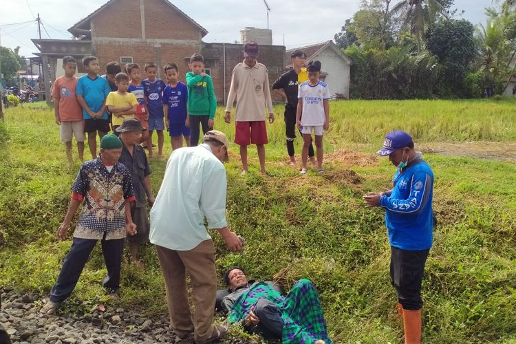 Kastu (64) warga Desa Sempol, Kecamatan Pagak, Kabupaten Malang tergeletak karena alami patah tulang akibat tersambar kereta api, Minggu (15/1/2023) sore.