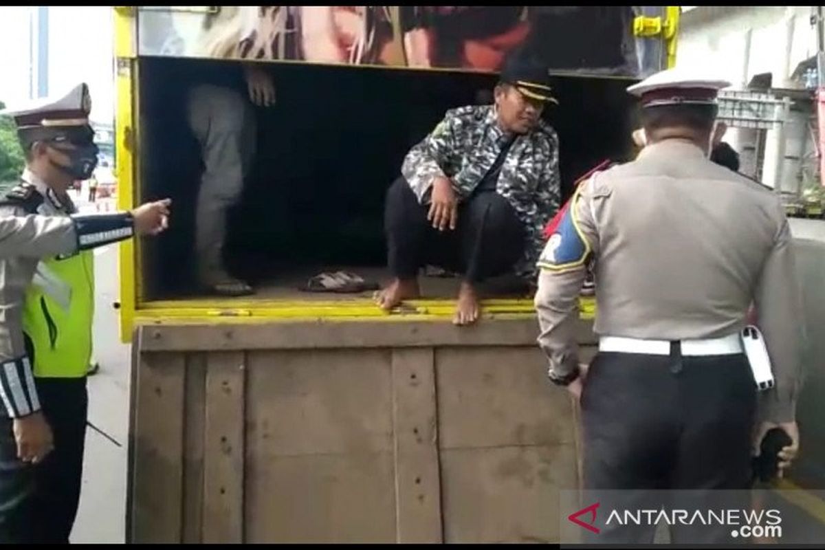 Anggota Direktorat Lalu Lintas (Ditlantas) Polda Metro Jaya memergoki sebuah truk menyelundupkan pemudik yang hendak keluar Jabodetabek di Pos Pengamanan Operasi Ketupat Jaya 2020 di GT Cikarang Barat, Jumat (1/5/2020).