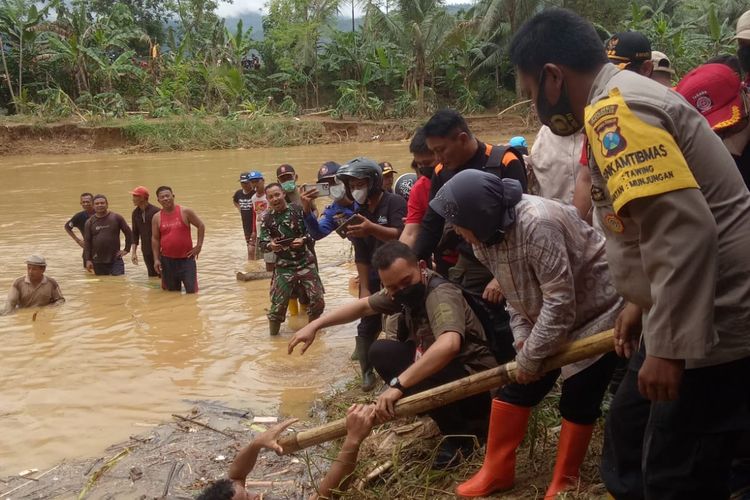 Menteri Sosial (Mensos) Tri Rismaharini turun langsung membantu petugas tanpa canggung saat mengunjungi lokasi titik banjir bandang di Sungai Kali Tengah. 