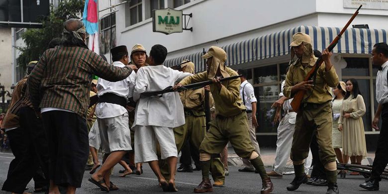 Warga terlibat saling dorong dengan pasukan Jepang di depan Hotel Majapahit saat teatrikal peristiwa perobekan bendera di Hotel Yamato (kini Hotel Majapahit) di Jalan Tunjungan, Surabaya, Jawa Timur, Rabu (19/9/2018). Kegiatan tersebut dalam rangka memperingati peristiwa perobekan bendera Belanda menjadi bendera Indonesia pada 19 September 1945.