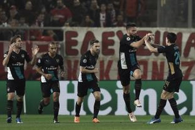 Para pemain Arsenal merayakan gol pertama Olivier Giroud ke gawang Olympiakos pada partai pamungkas Grup F Liga Champions di Stadion Georgios Karaiskaki, Rabu (9/12/2015).