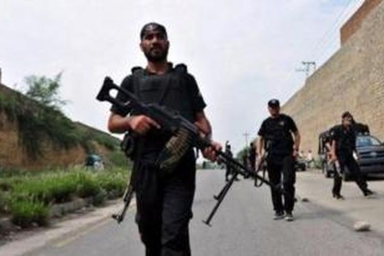 Sekelompok polisi terlihat berpatroli sambil membawa senjata berat di kota Peshawar, Pakistan.