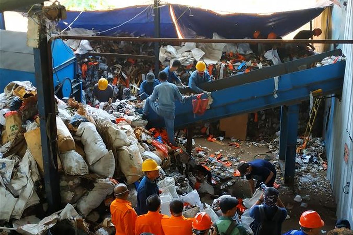 Petugas memasukkan sampah ke conveyer PLTSa Sumur Batu, Jumat (2/8/2019).