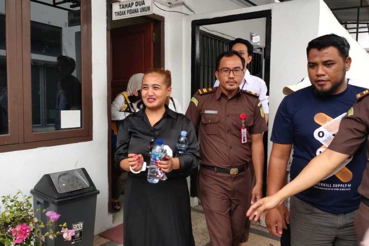 Lina Mukherjee tersangka kasus konten makan babi ketika keluar dari ruang penyidik Kejari Palembang untuk dibawa menuju ke mobil tahanan, Senin (10/7/2023).