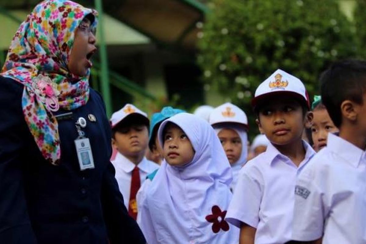 Anak-anak berbaris mengikuti upacara bendera pada hari pertama masuk sekolah di SDN 01 Menteng, Jakarta Pusat, Senin (18/7/2016).  Peraturan Menteri Pendidikan dan Kebudayaan Nomor 23 Tahun 2015 tentang Penumbuhan Budi Pekerti berisi, antara lain, tentang keterlibatan orangtua dalam pendidikan anak. Salah satu hal yang ditekankan ialah kewajiban orangtua mengantar anak ke sekolah pada hari pertama tahun ajaran baru.
