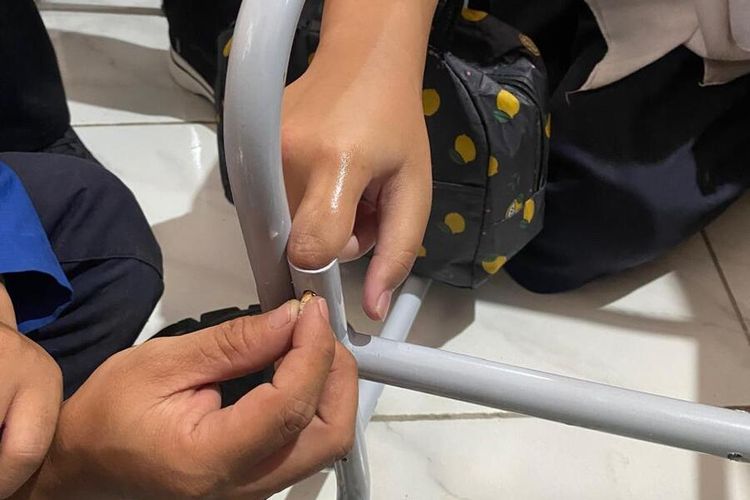Petugas Diskar PB tengah berupaya mengeluarkan jari siswi yang masuk kedalam lubang kursi, Rabu(15/1/2025)
