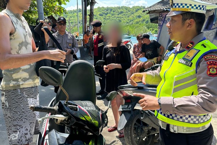 Polisi saat mengamankan WNA yang mengendarai sepeda motor mengunakan pelat palsu di Nusa Lembongan, Klungkung, Bali, pada Minggu (5/2/2023). /Humas Polda Bali