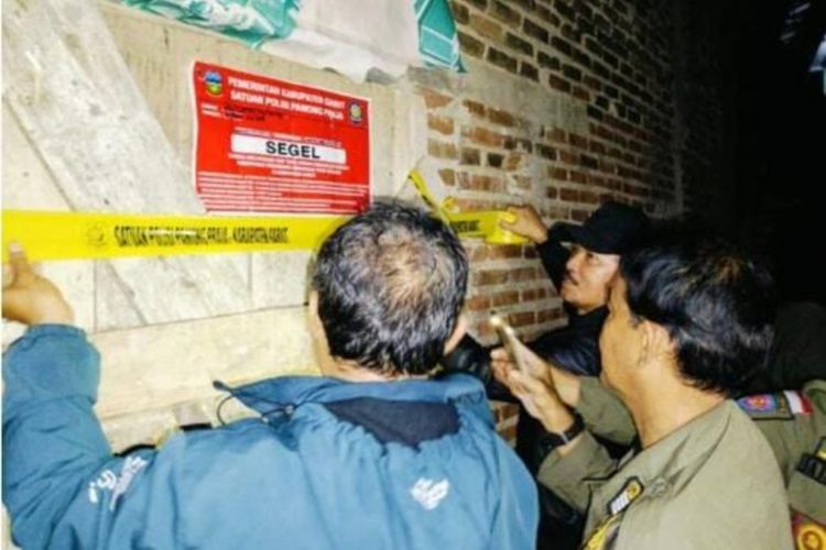 Sejumlah petugas Satpol PP Kabupaten Garut, memasang tanda segel sebagai tanda ditutupnya bangunan yang dijadikan kegiatan ibadah jamaah Ahmadiyah di Kampung Nyalindung Desa Ngamplang Kecamatan Cilawu pada Selasa (2/7/2024)