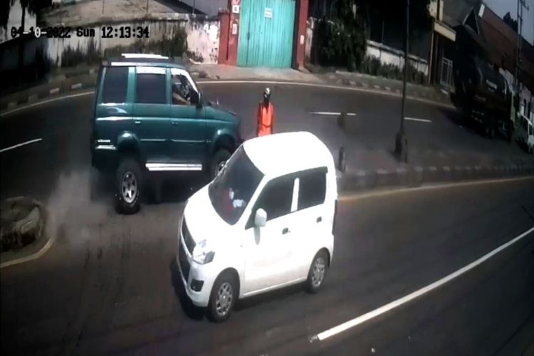 Tangkapan layar dari video seorang relawan pengatur lalu lintas tertabrak mobil yang videonya viral di media sosial, Senin (11/4/2022).