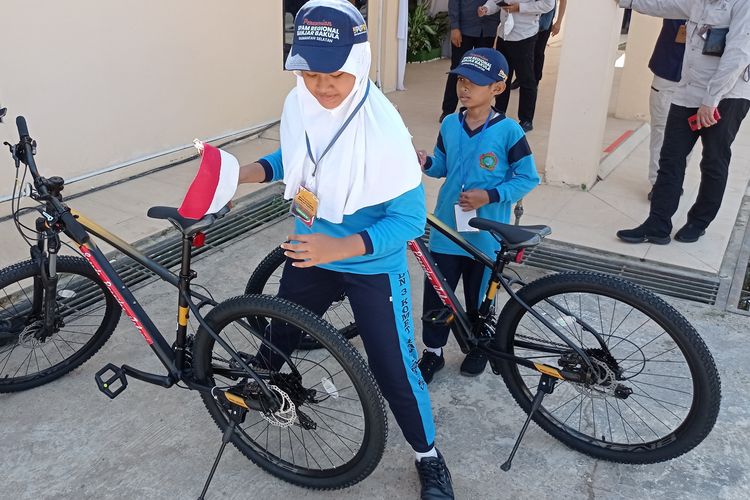 Erina dan Rio memperlihatkan sepeda setelah menjawab pertanyaan dari Presiden Jokowi pada acara peresmian SPAM Banjarbakula di Banjarbaru, Kalsel, Jumat (17/3/2023). 