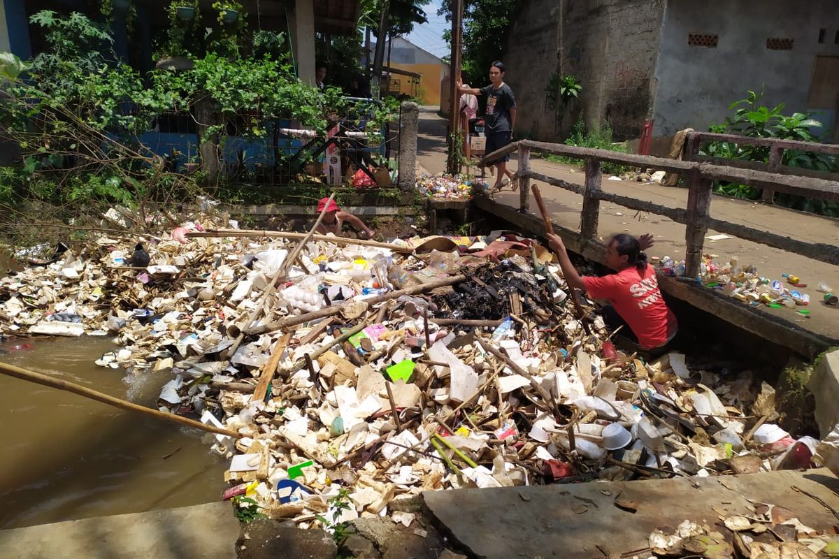 Warga Rt 01 RW 04 Kelurahan Cipayung Jaya, Kecamatan Cipayung, Kota Depok, sejak pagi bergotong-royong membersihkan sampah yang tersangkut di jembatan, Jumat (17/9/2021). 