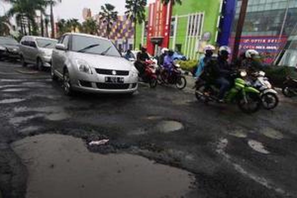 Jalan rusak akibat banjir, akan diganti dengan lapisan beton.