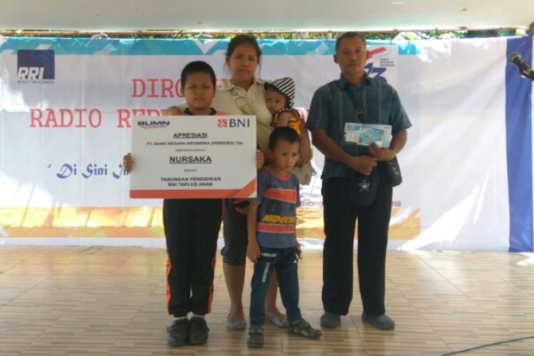 Nursaka didampingi kedua orangtuanya saat menerima beasiswa dari BNI Balai Karangan di Entikong, Kabupaten Sanggau, Kalimantan Barat, Rabu (12/9/2018).