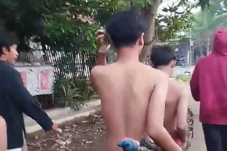Warga saat menggiring remaja pelaku diduga hendak tawuran yang berhasil diamankan menuju ke kantor polisi di  Blok Kasmaran, Desa Tambi Lor, Kecamatan Sliyeg, Kabupaten Indramayu, Jawa Barat, Minggu (21/9/2025).