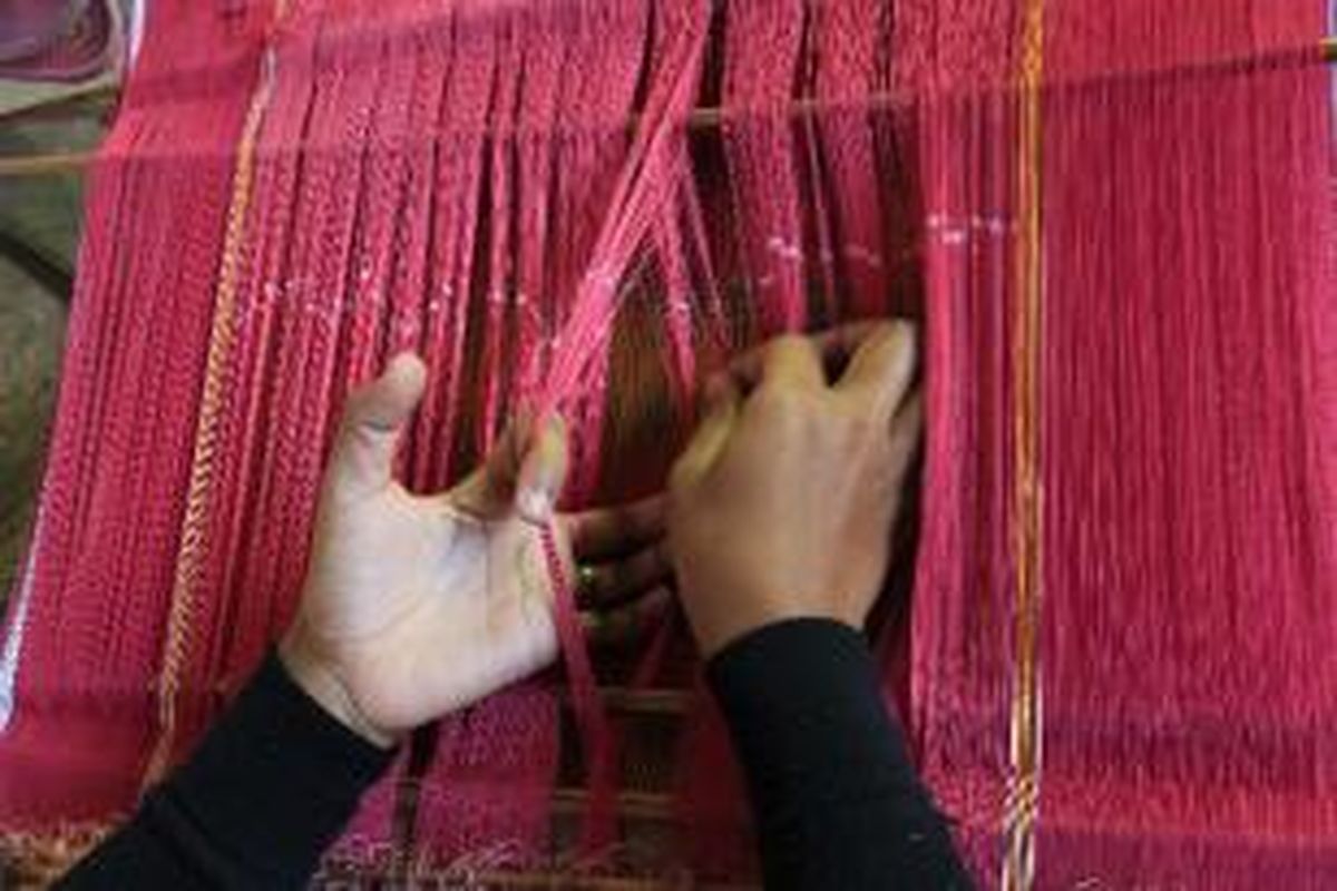 Warga menyelesaikan tenunan kain tradisional ulos di Desa Lumban Suhi-suhi, Kecamatan Pangururan, Kabupaten Samosir, Sumatera Utara, Sabtu (23/7/2011). Satu lembar kain ulos mereka selesaikan dalam satu minggu lamanya. Warga atas kemauan sendiri bisa turut menenun di tempat ini untuk berwirausaha selain berprofesi sebagai bertani.