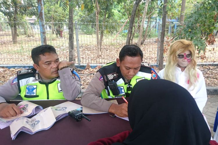 Salah satu hantu jadi-jadian (kanan) yang dihadirkan dalam agenda sidang di tempat, dalam operasi patuh 2019 yang dilaksanakan Satlantas Polres Gresik.