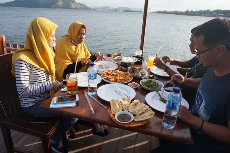 Pengunjung menikmati makanan di tepi Danau Sentani