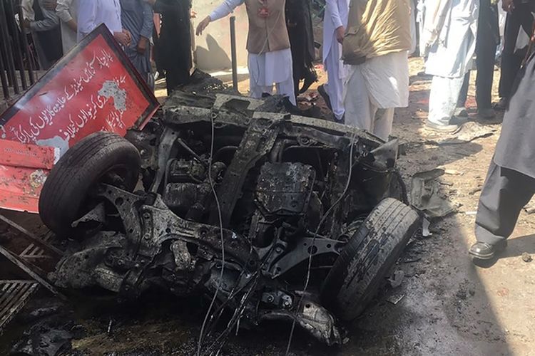 Warga menyaksikan bangkai mobil yang menjadi sumber ledakan di sebuah pasar di distrik Kurram, kawasan kesukuan Pakistan. Serangan bom itu menewaskan 22 orang.